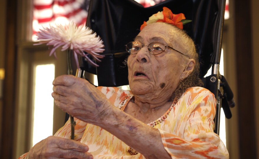 Gertrude Weaver holds a flower given to her a day before her 116th birthday last year, at Silver Oaks Health and Rehabilitation Center in Camden, Ark. Weaver, who last week was named the world's oldest person, died Monday.