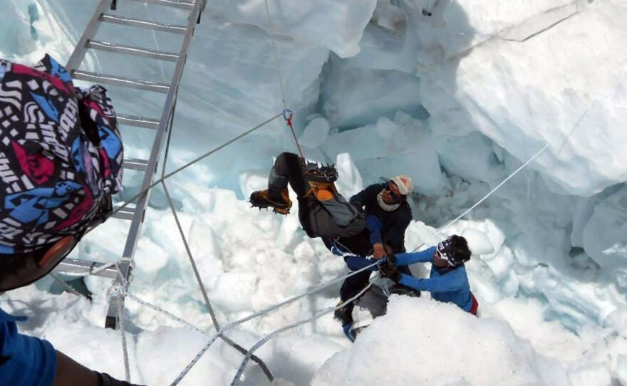 Nepalese search team members rescue a survivor of an avalanche on Mount Everest Friday. At least 13 Nepalese guides preparing routes for commercial climbers were killed by an avalanche in the most deadly mountaineering accident ever on the world's highest peak.
