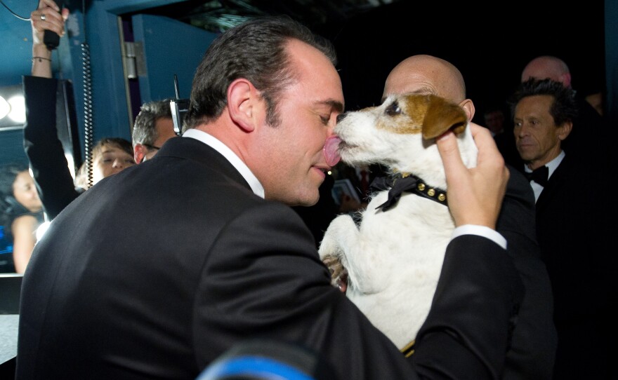 Best actor Jean Dujardin smooching the pooch who was probably key in helping the Frenchman win the award.