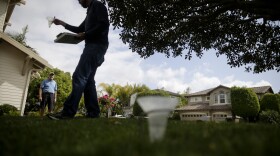 Glen Peterson, left, looks on as Dan Denning, a water conservationist for San Diego County Water Authority checks sprinkler flow on his lawn as part of the county's "Watersmart Checkup" in Carlsbad, May 6, 2015. 