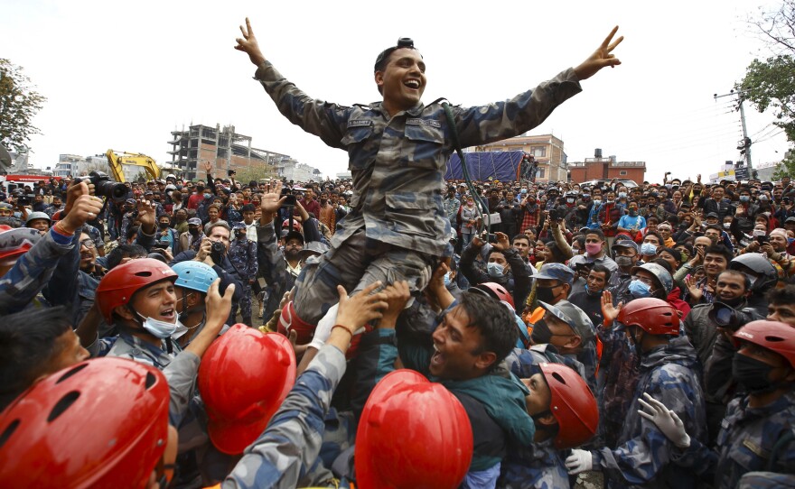 Members of Nepal's Armed Police Force carry an officer as they cheer the successful rescue of a teenager who had been trapped by Saturday's earthquake in Kathmandu.