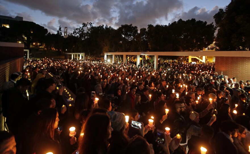Well-wishers hold up candles during Nohemi Gonzalez's memorial service on Sunday.