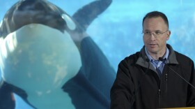 Jim Atchison, right, President & CEO of SeaWorld Parks & Entertainment, speaks during a news conference at the killer whale underwater viewing area of SeaWorld in Orlando. 