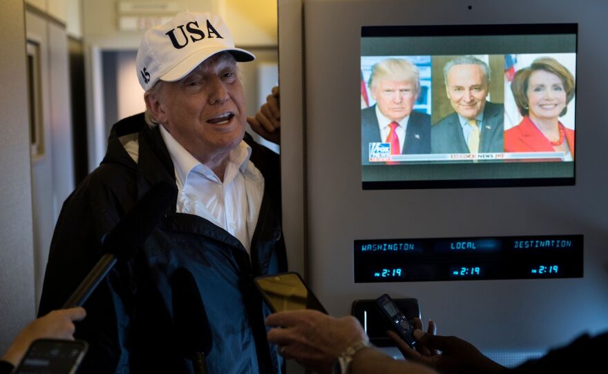 President Trump speaks to the press onboard Air Force One while flying back to Andrews Air Force Base from Florida on Thursday.