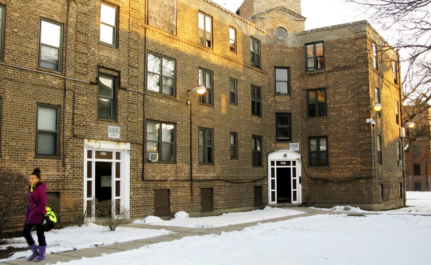 A resident of Lathrop Homes leaves one of the few occupied buildings in the development. The city wants to redevelop the public housing as mixed use, and offered vouchers to encourage residents to relocate.