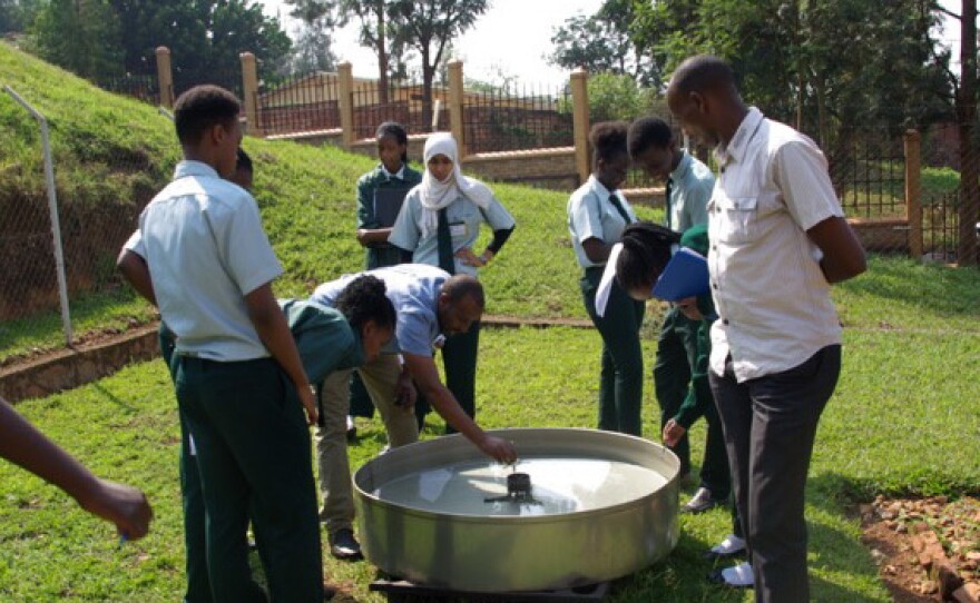 Rwandan officials inspect equipment at a weather observation station.