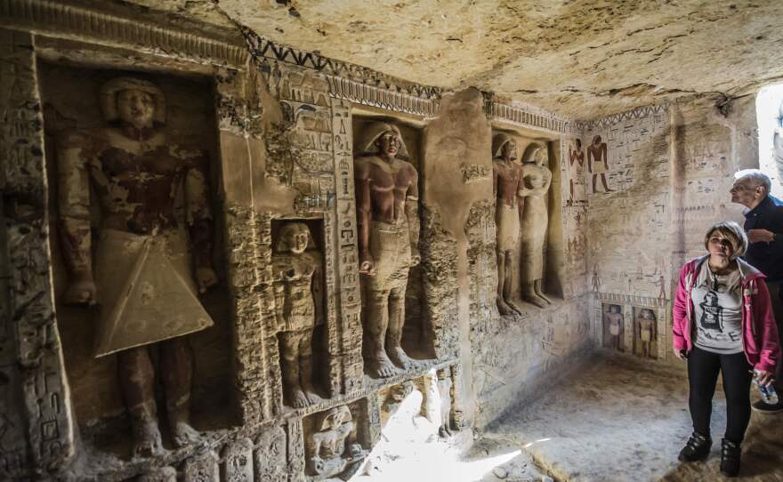 Visitors enter a newly-discovered Egyptian tomb at the Saqqara necropolis on Saturday.