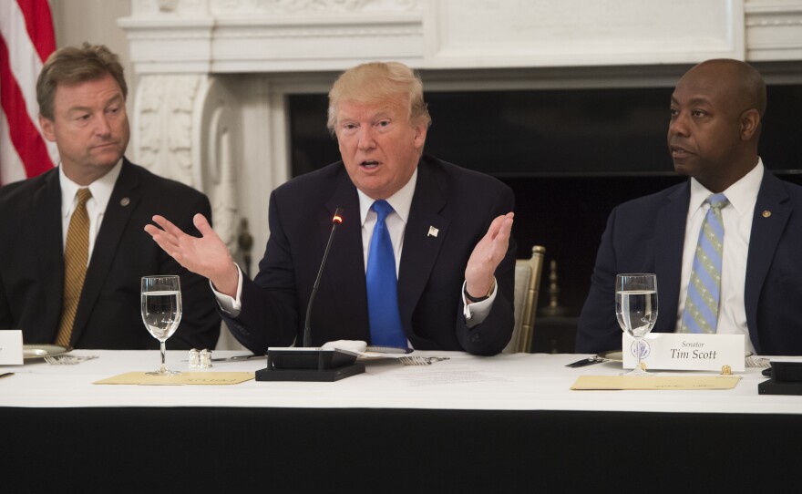 President Trump speaks alongside Republican Sens. Dean Heller of Nevada (left) and Tim Scott of South Carolina during a meeting with lawmakers to discuss the health care bill in the State Dining Room of the White House on Wednesday.