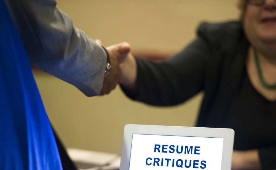 A job seeker stops at a table offering resume critiques during a job fair held in Atlanta.