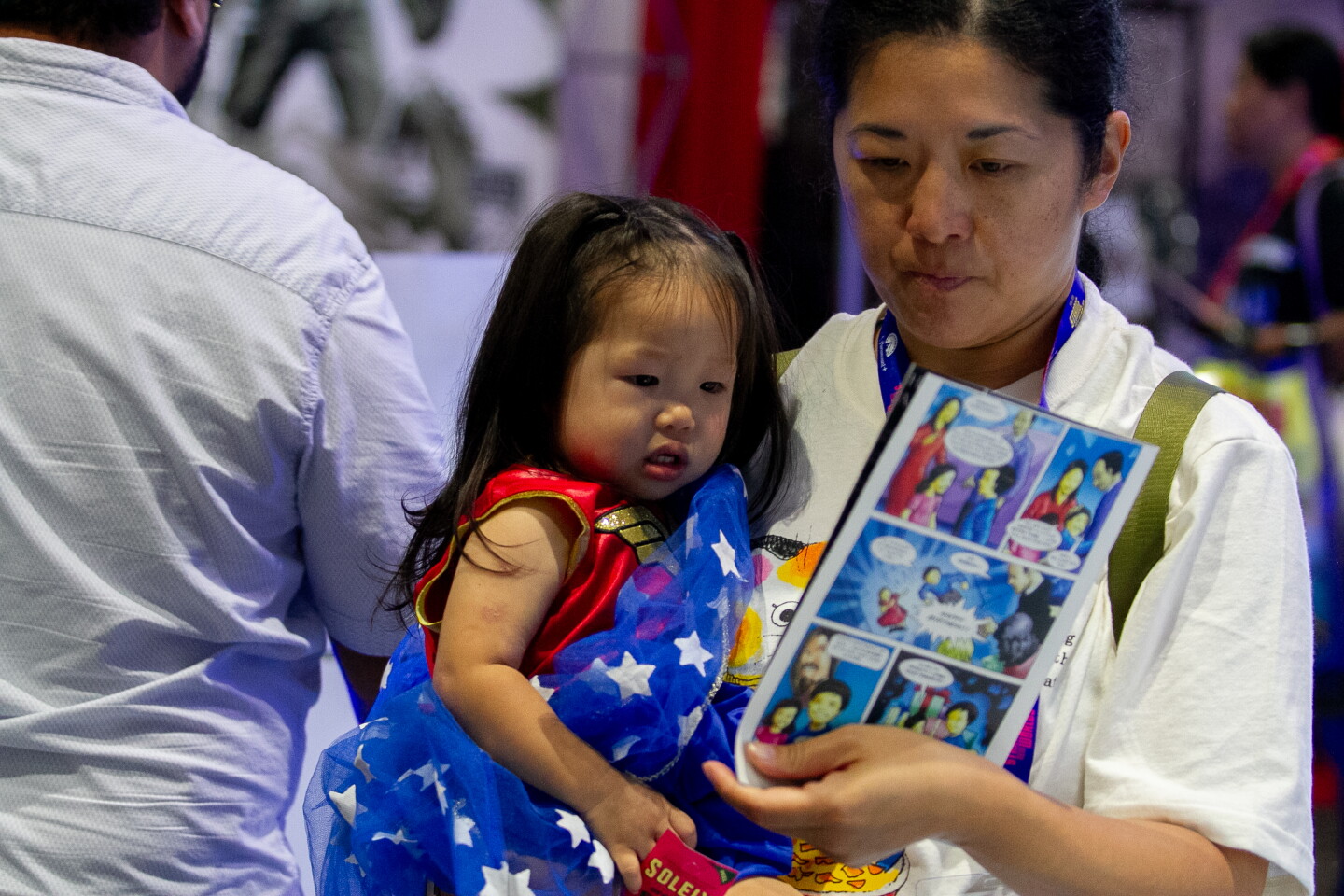 A mother and daughter look at a comic at Comic-Con, April 23, 2026.