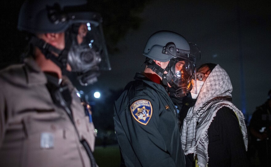 A pro-Palestinian protester confronts police as demonstrators clash at an encampment at UCLA Wednesday, May 1, 2024, in Los Angeles.