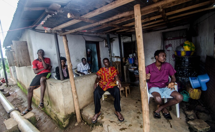 Members of the Koroma family relax Sunday at their quarantined home in Freetown.