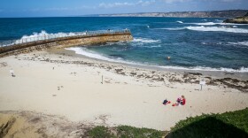 A family sits on the sand at Children's Pool Beach in La Jolla, CA in this undated photo. 