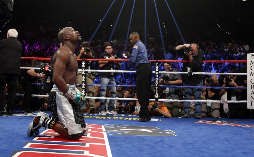 Floyd Mayweather Jr. kneels at the end of his welterweight title boxing bout against Andre Berto on Saturday, in Las Vegas. Mayweather says it's his last fight. If so, he retires with an undefeated record of 49-0.