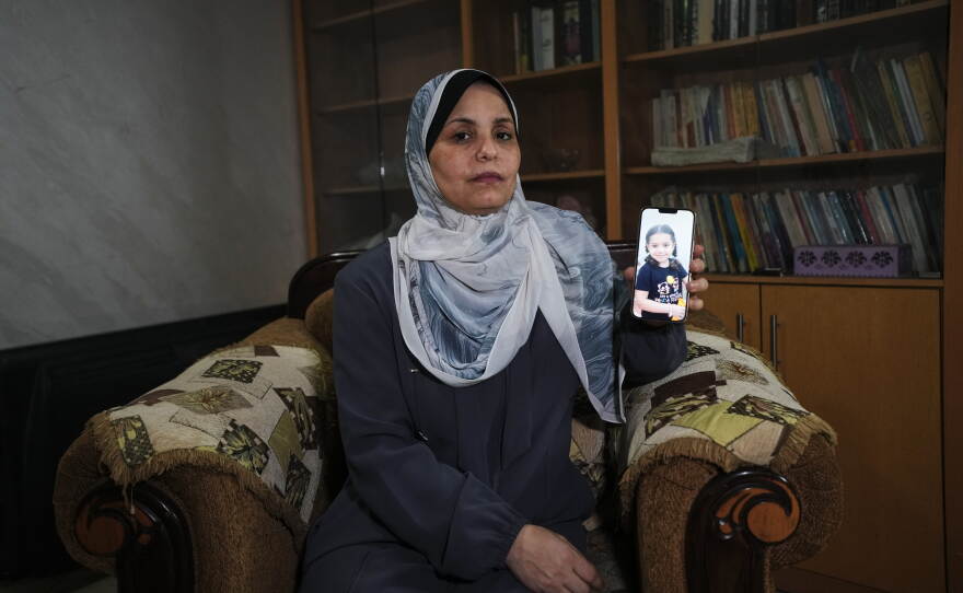 Hind Rajab poses in Gaza City, Wednesday, Aug. 19, 2026, with a photo of her granddaughter, Hind Rajab, a 5-year-old Palestinian girl who was killed alongside her family in Gaza in February 2024.