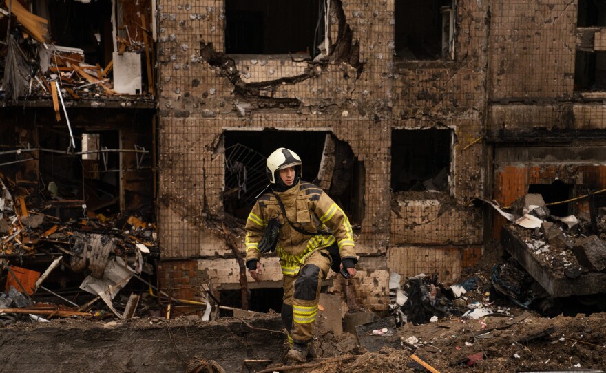 Firefighters and emergency service workers work the scene at a residential building in Kyiv that was damaged in a Russian missile strike on Tuesday.