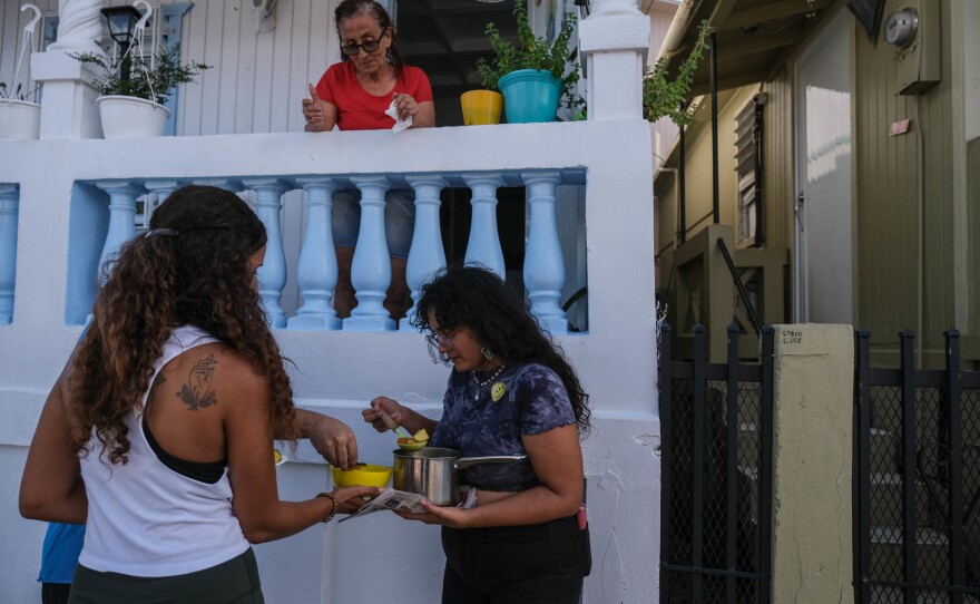 Norimar Maldonado and other participants of Saturday's "sancocho comunitario" event, hosted by Huerto Callejón Trujillo, deliver food door to door in Ponce Playa.