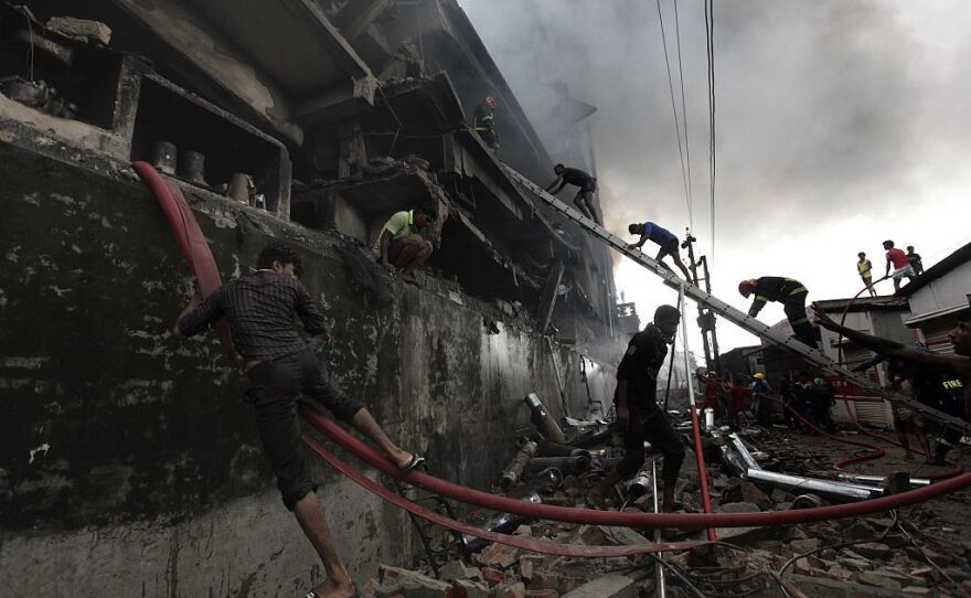 Bangladeshi firefighters and volunteers work to put out a fire and search for survivors at the site of an explosion in a factory in Tongi.