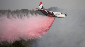 Rural Fire Service large air tanker 134, operated by Coulson Aviation in the U.S. state of Oregon, drops fire retardant on a wildfire burning close to homes at Penrose, Australia, 165km south of Sydney, Jan. 10, 2020. 