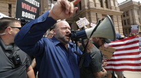Infowars' Alex Jones speaks during an "Open Texas" rally at the Texas State Capitol to protest the state's stay-at-home order because of the COVID-19 pandemic, Saturday, April 25, 2020, in Austin, Texas. 