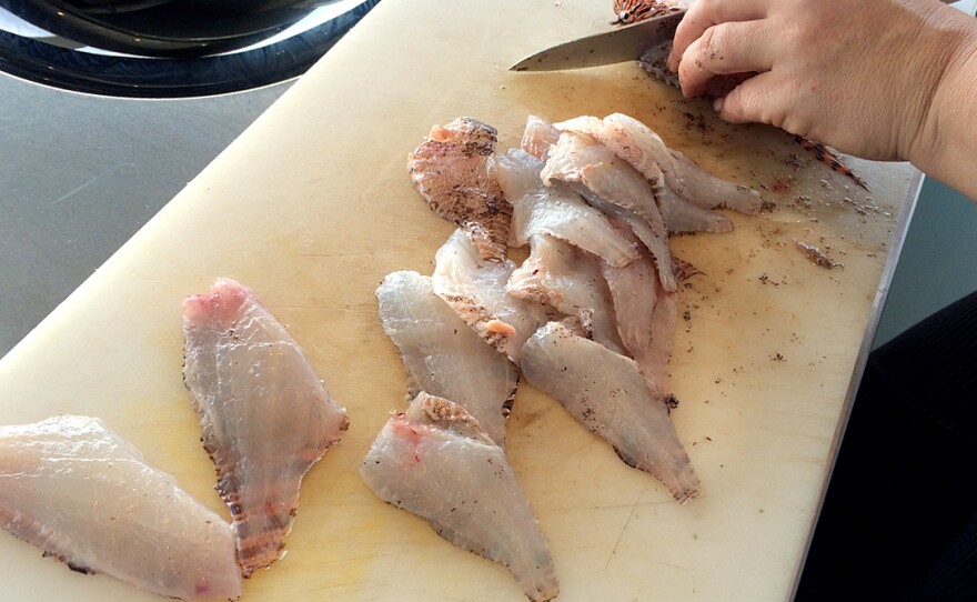 Chef Ellen Bross fillets lionfish caught by Sean Carberry.