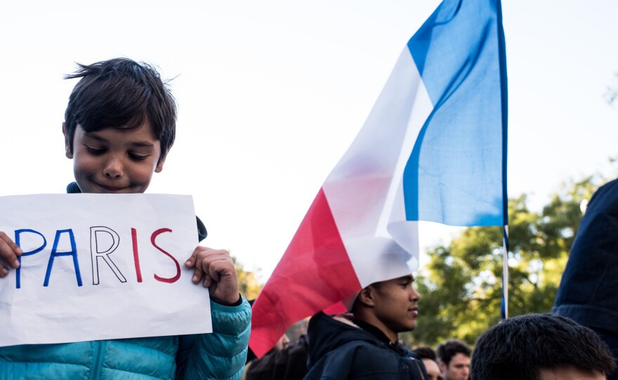 People hold signs and flags while attending a vigil held for the victims of the Paris terror attacks in Washington Square Park on November 14, 2015, in New York City. Searches related to the deadly attacks in Paris were among the most popular Google queries of the year.