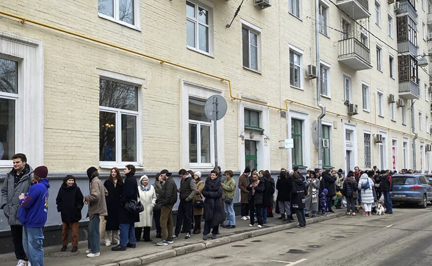 Voters queue at a polling station in Moscow on Sunday. The Russian opposition has called on people to head to polling stations at noon on Sunday in protest as voting takes place on the last day of a presidential election that is all but certain to extend President Vladimir Putin's rule after he clamped down on dissent.