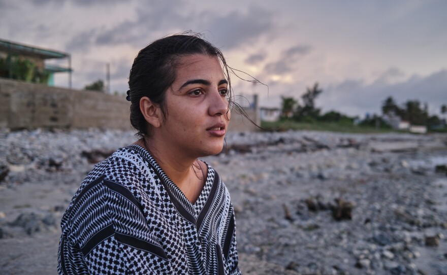 Lauren Rodriguez Ruiz, 26, sits on the beach in the neighborhood where she lives. In the month and a half that her boyfriend, Jan Perez Suárez, was on the way from Cuba, via Nicaragua, El Salvador, Guatemala and Mexico, and via a <em>coyote,</em> or people smuggler, to the U.S., she asked the sea for protection. It was the only place she could rest.