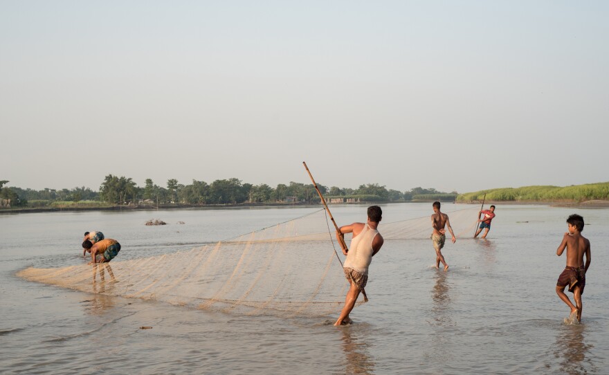 Young men fish in the Brahmaputra River. The river serves as a source of livelihood and transportation, but when it floods, it is also a source of destruction.