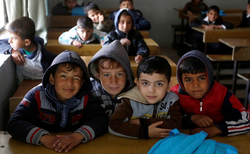 Schoolchildren pose for a photo in a classroom at the al-Kufa school in Mosul.