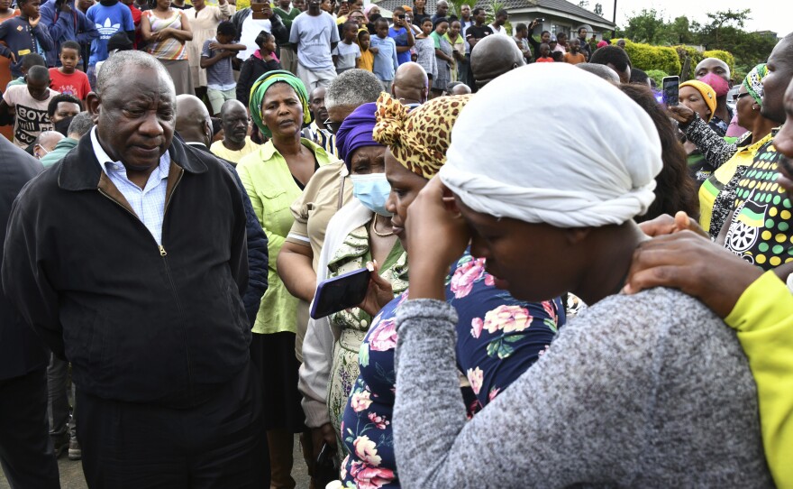 South African President Cyril Ramaphosa, left, speaks to various grieving family members, as part his visit and assessing the damage following the heavy rainfall which resulted in roads collapsing, properties damaged and lives lost outside of Durban.