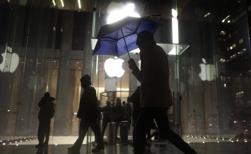 A pedestrian walks by an Apple store in New York City on Feb. 23. Protesters demonstrated against the FBI's efforts to require the company to make it easier to unlock the encrypted iPhone used by Syed Rizwan Farook.
