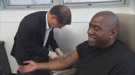 Dr. David Ho, HIV/AIDS specialist, draws blood from Magic Johnson.