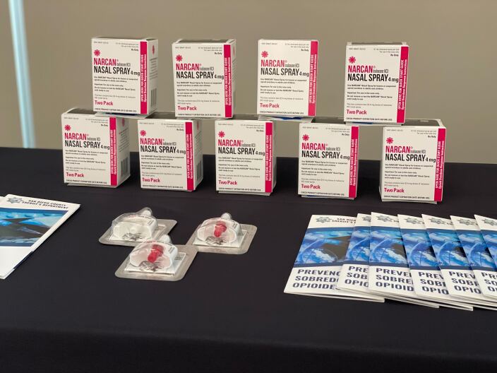 A table full of Narcan Nasal spray and informational packets on opioids is organized at a press conference, Jan. 23, 2023.