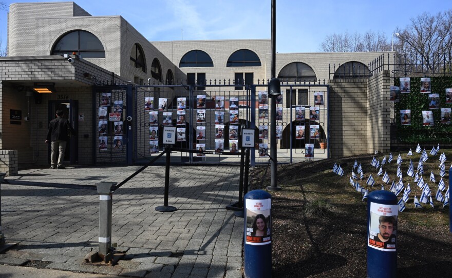 A man enters the Israeli embassy, near pictures of hostages in Gaza, in Washington, D.C., on Monday. An airman has died after self-immolating in what he said on social media was an act of protest against Israel's war in Gaza.