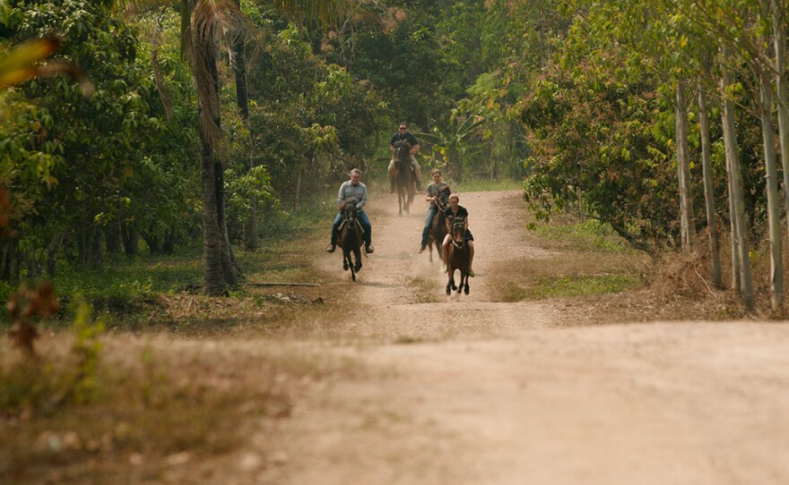 Craig Martin and Earl Bridges try to keep up on horseback as they work out with the rangers on the "Ranger Runs" and wading through swamps as they train in Northern Thailand.