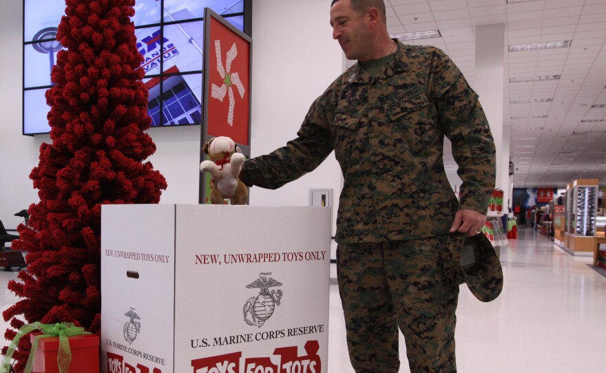 Master Gunnery Sgt. Gary S. Teicher, the ordnance Chief for 1st Marine Division here, places a stuffed animal into a toy donations box at the Marine Corps Exchange here, Dec. 20. 