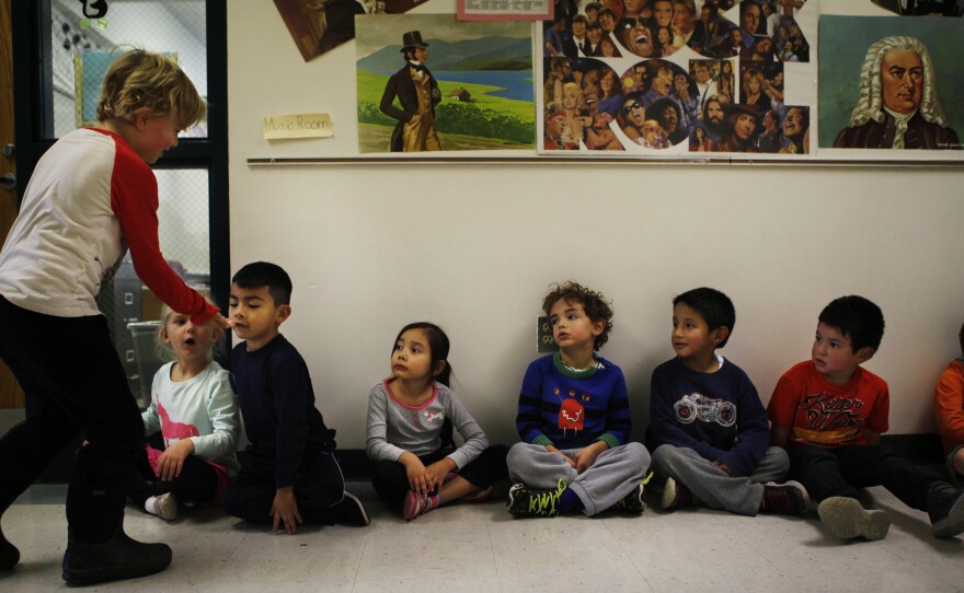 A student shows off his lost tooth to his classmates.