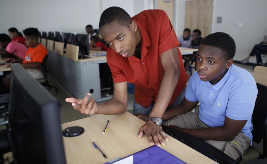 Darryl Burrell, a junior at Morgan State, helps rising seventh-grader Antonne Richardson, 11, build his 3-D ruler.