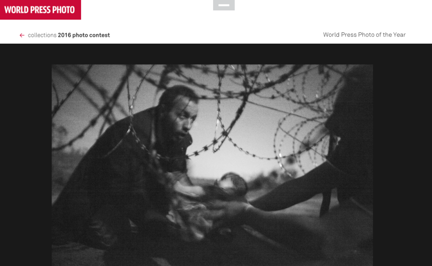 A man passes a baby through the fence at the Serbia/Hungary border in Röszke, Hungary, 28 August 2015.