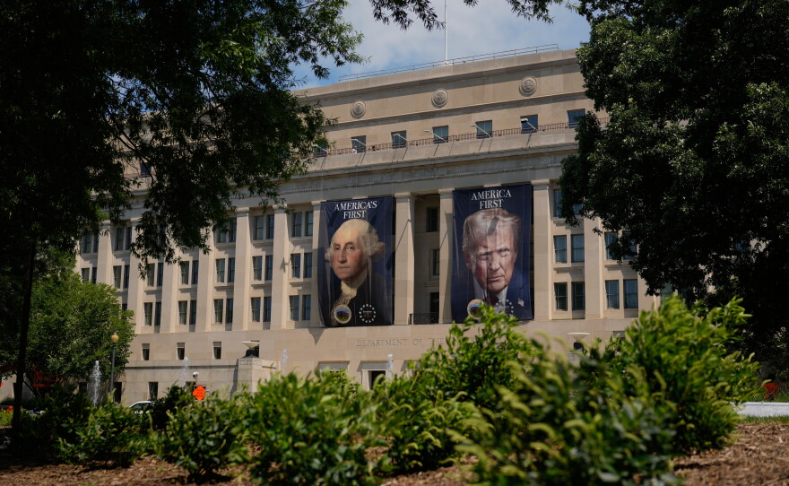 Banners of former President George Washington and President Donald Trump hang above an entrance to the Department of the Interior, Thursday, June 25, 2026, in Washington.