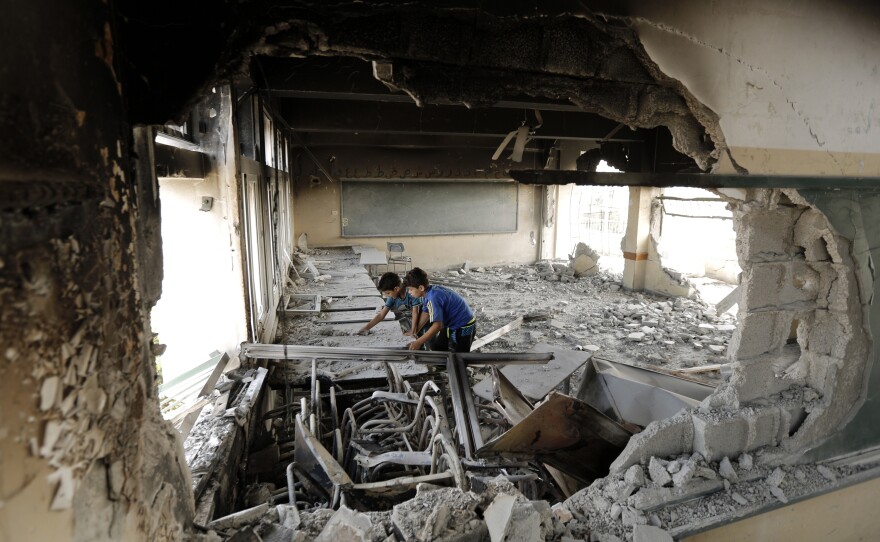 Palestinian children stand in a heavily damaged school in Gaza City on Aug. 5, 2014. Many civilian buildings were damaged and many Palestinian civilians were killed in the 50 days of fighting.