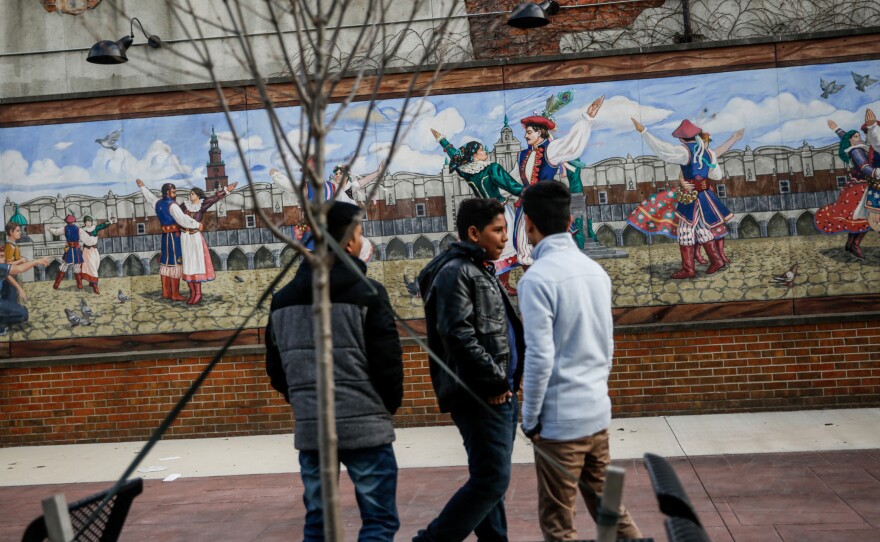 (Top) In downtown Hamtramck, teenagers hang out in Pope Park, which commemorates the Polish Pope John Paul II's visit to the city in 1987. (Bottom left) Co-owner Jamal Jawany poses for a portrait at Delite Cafe and Deli. (Bottom right) Ezzi Jawany, 74, waits for his order at his son's deli, Delite Cafe.