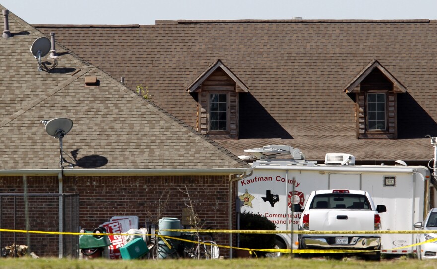 The home of Kaufman County District Attorney Mike McLelland is surrounded by police tape in Forney, Texas, on Monday. Authorities launched a massive investigation into the weekend killings of McLelland and his wife.