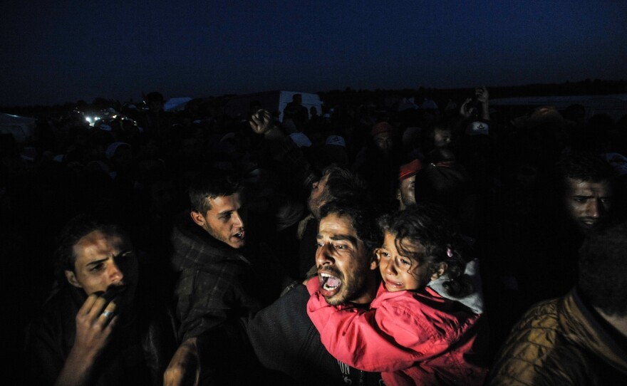 Hungarian police officers stop a group of refugees near a makeshift camp for asylum seekers in Roszke, southern Hungary, in September 2015.