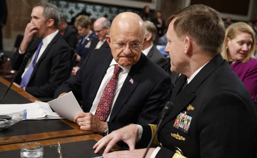 Director of National Intelligence James Clapper (center) talks with National Security Agency and Cyber Command chief Adm. Michael Rogers prior to testifying before the Senate Armed Services Committee.