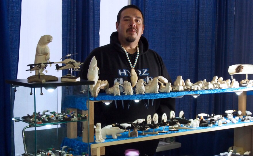 Dennis Pungowiyi sells his ivory carvings at a craft fair during the annual Alaska Federation of Natives conference.