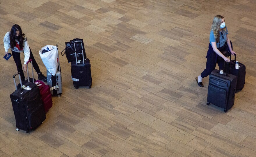Travelers wearing protective face masks arrive to Ben Gurion Airport near Tel Aviv, Israel on Sunday. Israel on Sunday approved barring entry to foreign nationals as part of its efforts to clamp down on a new coronavirus variant.