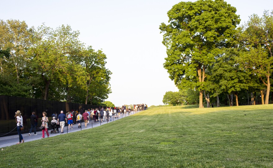 Visitors walk along the Vietnam Veterans Memorial. A new sign warns visitors that human remains left there will not be added to the memorial's permanent collection.