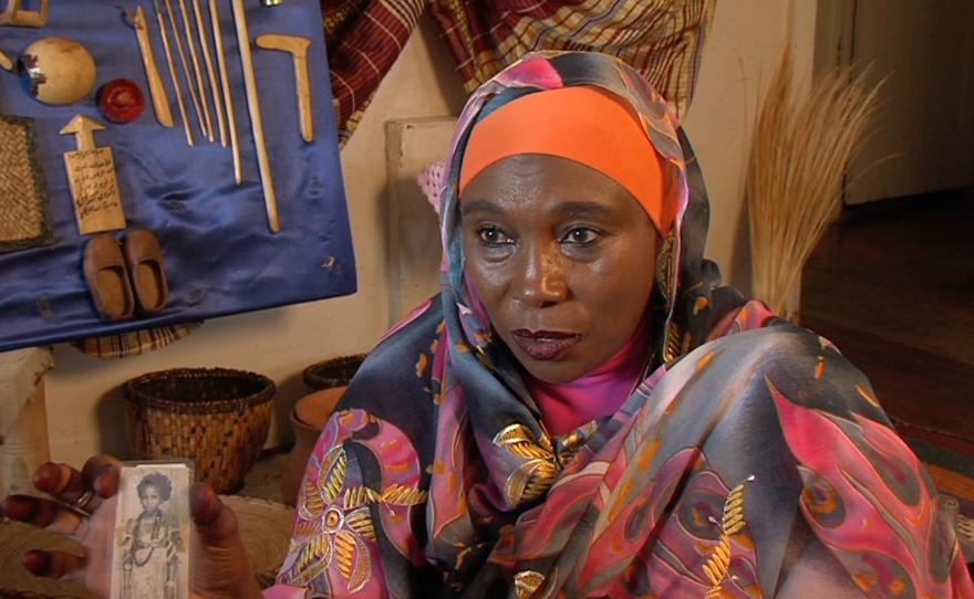 Fatima Abdelrahman holds up a picture of when she was genitally mutilated in Sudan, Aug. 2, 2016.